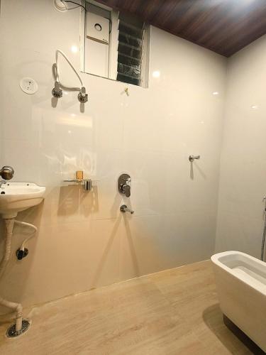 a white bathroom with a sink and a shower at Mio Boutique Hotel - Just Launched in Hyderabad