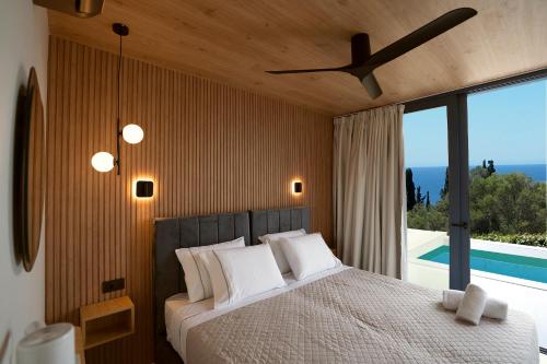a bedroom with a bed with a view of a pool at Avithos Blue Villas in Svoronata