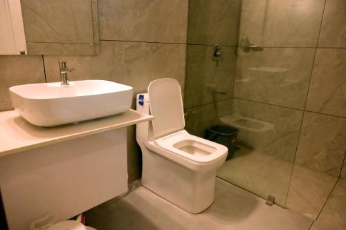 a bathroom with a sink and a toilet and a shower at Shade trees in Padinjarathara