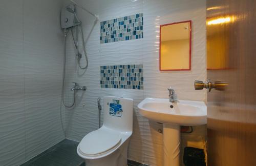a bathroom with a toilet and a sink at Algers Suites Bayan-Bayanan Marikina City in Manila