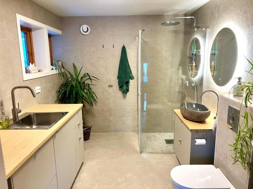 a bathroom with a shower and a sink and a toilet at Aurora beach house in Trondalen