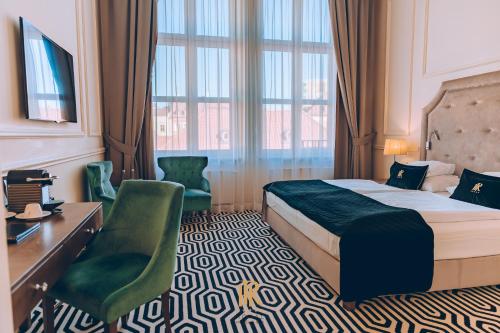 a hotel room with a bed and a desk and a window at Hotel Royal & Spa in Białystok