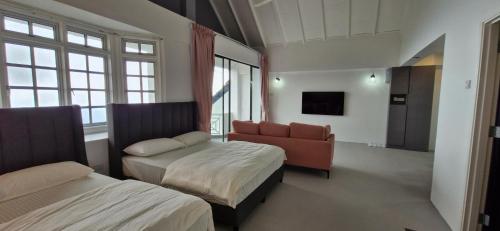 a room with two beds and a couch and a chair at A3-6-1Silverpark LuxMountsin view Lifted unit in Bukit Fraser