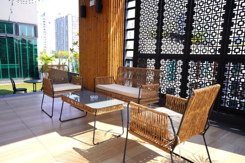 a patio with chairs and a table on a building at Kokotel Bangkok Sukhumvit 50 in Bangkok