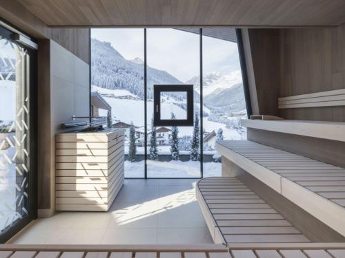 a room with a large window with a mountain view at ELVA PREMIUM APARTMENT HOTEL inklusive Sommerpass STUBAI SUPER CARD in Neustift im Stubaital