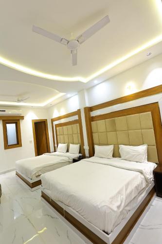 two beds in a hotel room with a ceiling at Hotel Amar Singh Palace in Agra