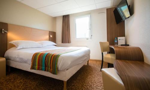 a hotel room with a bed and a television at Brit Hotel Le Kerann Nantes St Herblain - Zac De La Lorie in Saint-Herblain