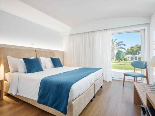 a bedroom with a large bed and a window at Comer Kinetta Beach in Kineta