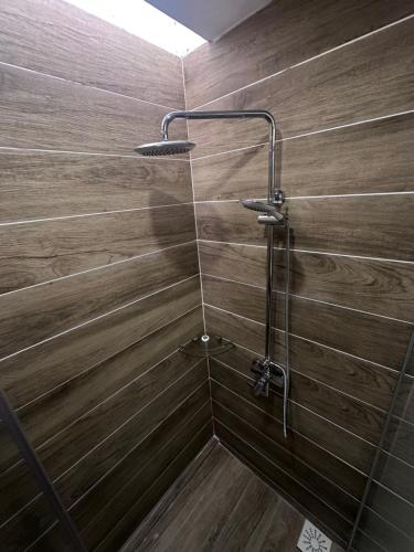 a shower with wooden walls and a shower head at 56 Hotel Block B in Kuching