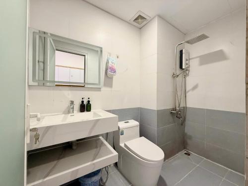a bathroom with a toilet and a sink and a mirror at The Sun Avenue - TPHomes in Ho Chi Minh City