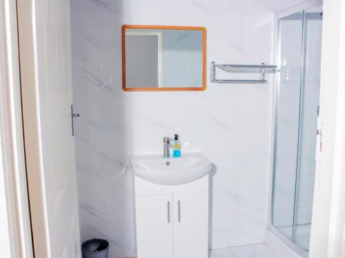 a white bathroom with a sink and a mirror at Samanyanga Resort in Kariba