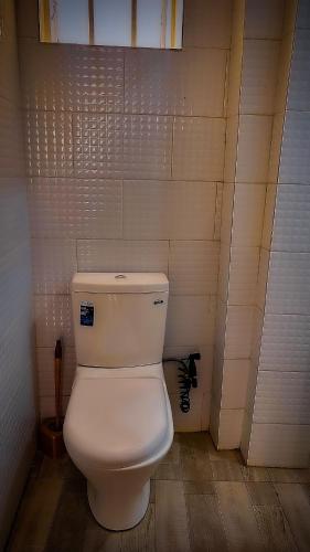 a bathroom with a white toilet in a room at Kigombe River Motel- musanze in Ruhengeri