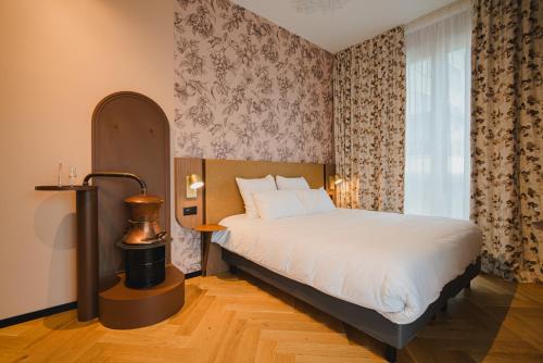 a bedroom with a bed and a lamp and a window at Hota Hotel Porrentruy in Porrentruy