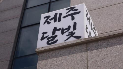 a sign on the side of a building with asian writing at Jeju Dalbit Pension in Jeju