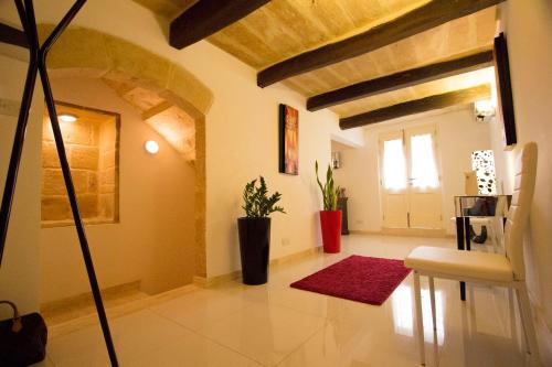 a living room with a red rug and a door at Valletta-Central duplex maisonette in Valletta