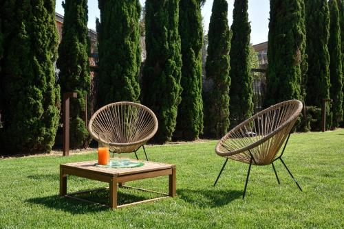 two chairs and a table with a candle on the grass at Ville Borgo Verde in Vada