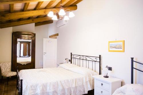 a white bedroom with two beds and a window at Locanda cireneo in Lugnano in Teverina