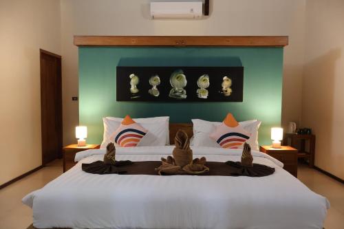 a bedroom with a large white bed with a blue headboard at Dolce Magia in Gili Trawangan