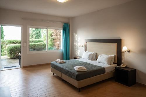 a bedroom with a bed and a large window at Thalassa Hotel in Paleros