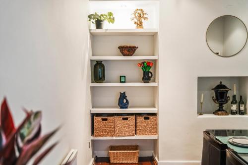 a hallway with white shelves with baskets and vases at Elegant 5-Bed House Free Parking Edgbaston, Birmingham in Birmingham