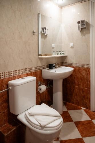 a bathroom with a toilet and a sink at Thalassa Hotel in Paleros