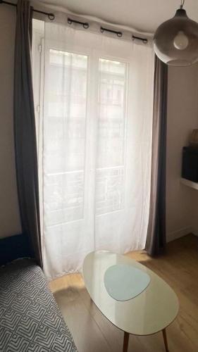 Suite Soleil Doré في أولينز: غرفة بها طاولة أمام نافذة