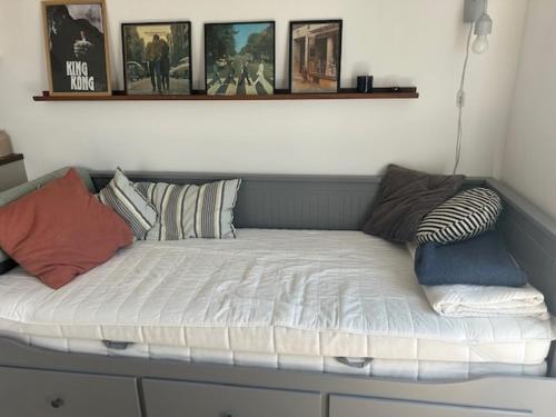 a bed with pillows on it in a room at Cosy guesthouse close to cities in Hjärup