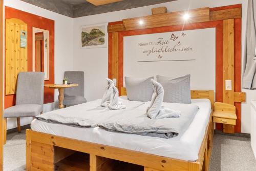 a bed in a room with two white shoes on it at Pension Schrammsteinbaude in Bad Schandau