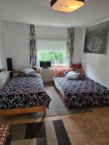 a bedroom with two beds and a window at Lieber Gruß 38 in Papenburg