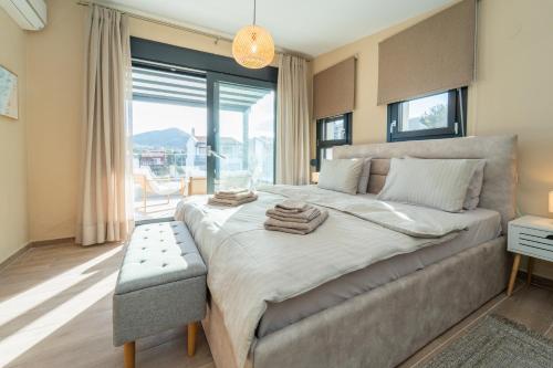 a bedroom with a large bed and a large window at Aegean Grace Villa in Iraklitsa