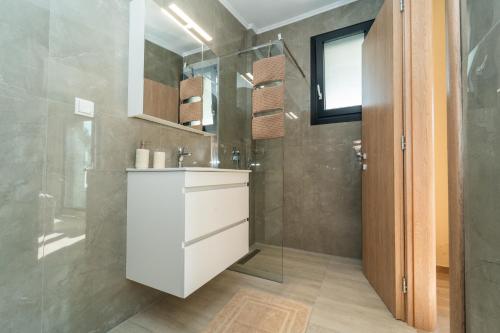 a bathroom with a sink and a shower at Aegean Grace Villa in Iraklitsa