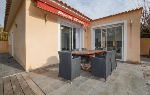 a patio with a wooden table and chairs at Villa Piscine Privative in Saint-Florent