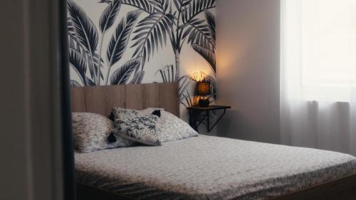 a bedroom with a bed with a headboard with a mural at La Kaz Eden * * * * in Les Cocos