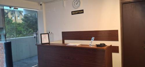 an office with a reception desk with a clock on the wall at Chippy Inn Tharamani in Chennai