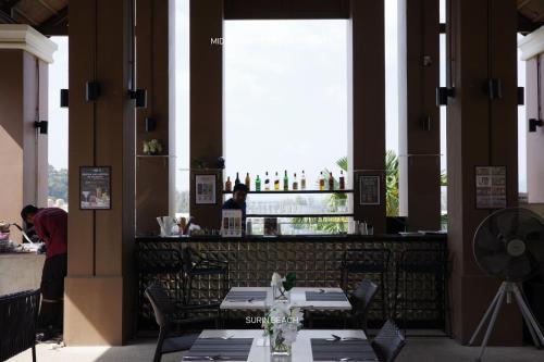 a restaurant with a bar with tables and chairs at Suite With Sea View By Mida Grande Resort in Surin Beach