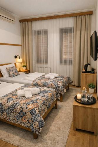 a hotel room with two beds and a television at Bed and Breakfast Vijecnica in Sarajevo