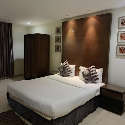 a bedroom with a large bed with a wooden headboard at شقق ذرا الماضي المخدومه2 in Al Bukayriyah