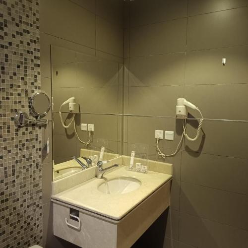 a bathroom with a sink and a mirror at شقق ذرا الماضي المخدومه2 in Al Bukayriyah