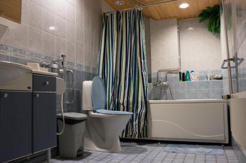 La salle de bains est pourvue de toilettes, d'une baignoire et d'un lavabo. dans l'établissement Gasthaus Mikkeli, à Mikkeli