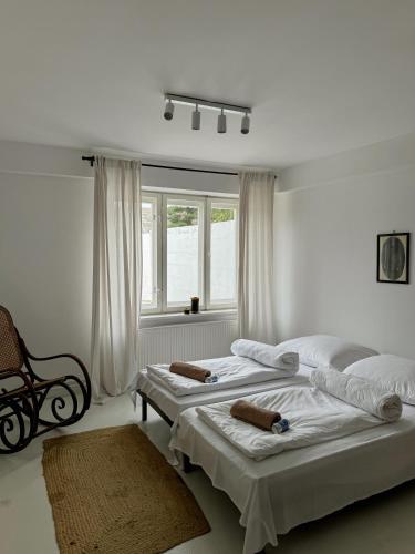 two beds in a white room with a window at Rusiborek Slow in Murzynowo Kościelne