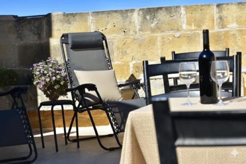 a table with two chairs and a bottle of wine at St George of Lydda B&B in Victoria