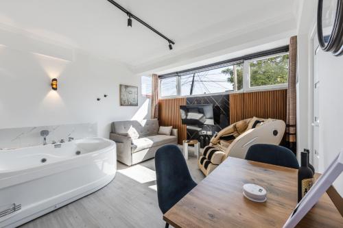 a living room with a bath tub and a dining room at Green Luxe Suite 2 by PikHost in Shkodër
