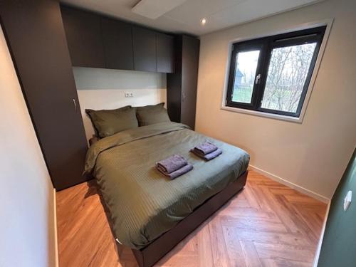 a bedroom with a bed with two towels on it at Tiny House 'Het Chalet' in Berlicum