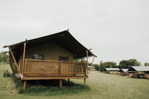 a large wooden house with a porch on a field at Drovers Rest Farm Stay in Hay-on-Wye