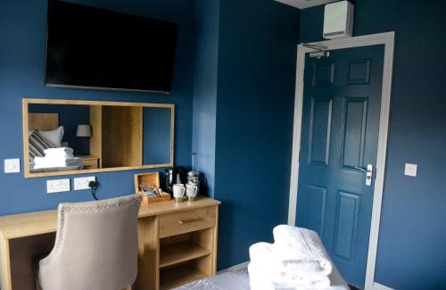 a room with a blue wall with a desk and a door at The Ugly Duckling in Telford