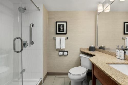 a bathroom with a toilet and a shower and a sink at Holiday Inn Oakville Centre by IHG in Oakville
