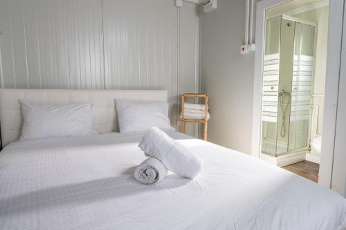 a white bed with a rolled up towel on it at אגם בגליל -וילה ו-3 סוויטות מקסימות למשפחות עם בריכה מחוממת in Wadi Keren