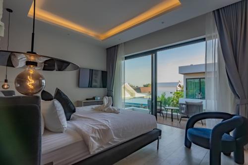 a bedroom with a bed and a view of a balcony at Dara Villas - Rawai in Rawai Beach