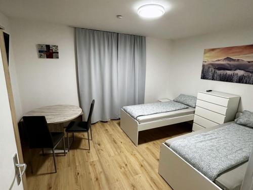 a room with two beds and a table and a desk at Apartment in Bergkamen in Bergkamen