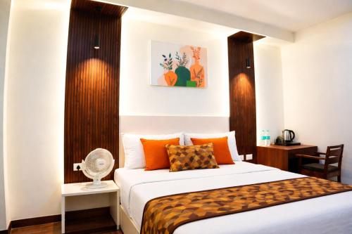 a bedroom with a bed and a desk with a fan at Mandola Stays in Girgaon